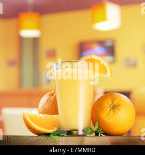 Frutti di colore arancione e un bicchiere di succo di arancia sulla barra . Foto Stock