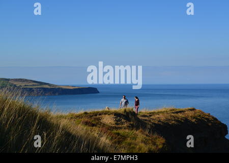 Giovane camminando lungo la scogliera azzurro del cielo e del mare Foto Stock