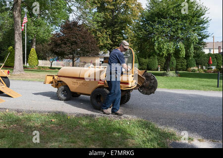 Un uomo con un modello di Rayco Super RG50 4X4 moncone smerigliatrice per rimuovere un ceppo di albero in Rhode Island USA Foto Stock