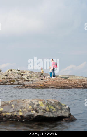 La mamma con bambini sky a passi da un lago di montagna vicino alla sommità del monte Åreskutan, Åre, Svezia Foto Stock