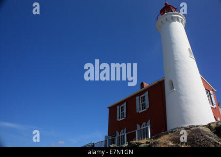 Il bianco e il rosso faro contro estate cielo blu chiaro Foto Stock