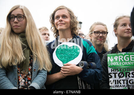 Oslo, Norvegia. Xxi Sep, 2014. Un giovane uomo porta un cuore verde come migliaia marzo attraverso il centro di Oslo, Norvegia, a sostegno di un'azione sul cambiamento climatico globale, 21 settembre 2014. Secondo gli organizzatori di "Il popolo del clima marzo", la dimostrazione di Oslo è stato uno dei 2,808 solidarietà eventi in 166 paesi, che essi rivendicazione era "il clima più grande marzo nella storia". Credito: Ryan Rodrick Beiler Alamy/Live News Foto Stock