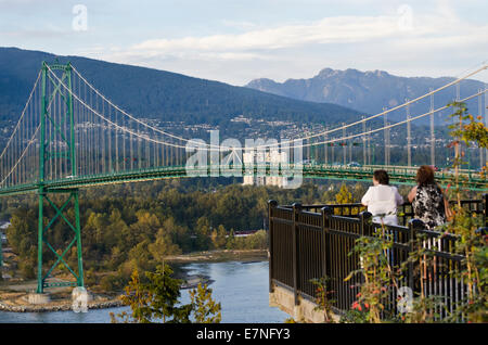 Due donne visualizzazione della Porta del Leone e il Ponte North Shore Mountains in Vancouver. Dal punto di prospettiva a Stanley Park. Foto Stock