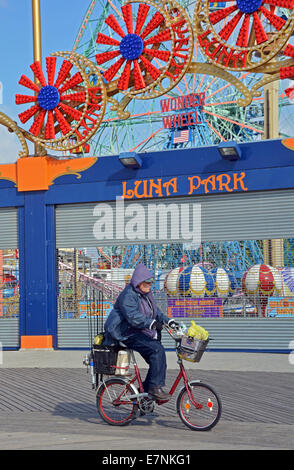 Un ciclista sul lungomare di Coney Island a Brooklyn, New York all' inizio dell' autunno. Foto Stock