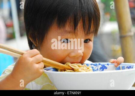 Ragazza mangiare tagliatelle Foto Stock