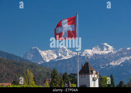 Castello, Oberhofen, il lago di Thun, molla, Canton Berna, Alpi Bernesi, Oberland bernese, Jungfrau, Monaco, il Mönch e l'Eiger, bandiera, bandiere, Sw Foto Stock