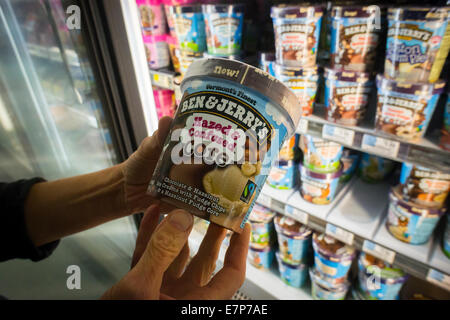 Un acquirente sceglie una pinta di Ben & Jerry's "Hazed & confuse" gelato in un congelatore in un supermercato a New York Foto Stock