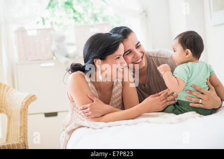 Famiglia con bambino figlio (6-11 mesi) in camera da letto Foto Stock