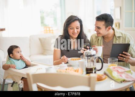 Famiglia con bambino figlio (6-11 mesi) in sala da pranzo Foto Stock