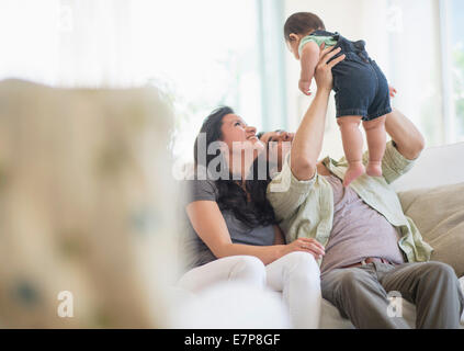 Famiglia con bambino figlio (6-11 mesi) nel soggiorno Foto Stock