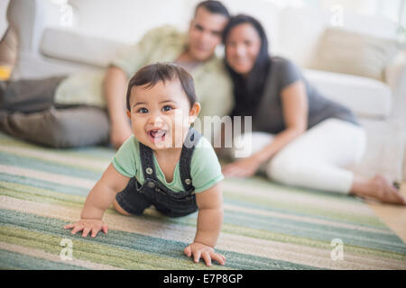 Famiglia con bambino figlio (6-11 mesi) nel soggiorno Foto Stock