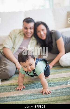 Famiglia con bambino figlio (6-11 mesi) nel soggiorno Foto Stock