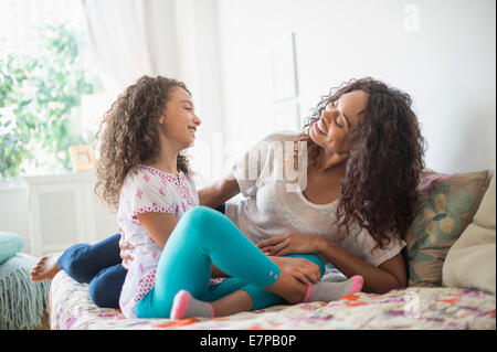 Madre e figlia (8-9) seduto sul letto Foto Stock