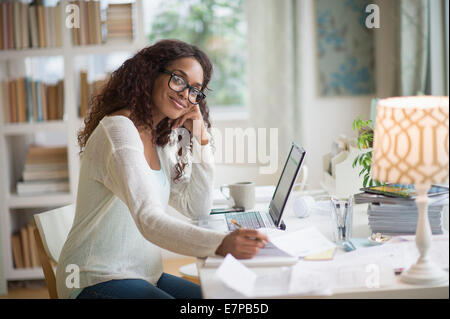 Donna che utilizza computer portatile in ufficio in casa Foto Stock