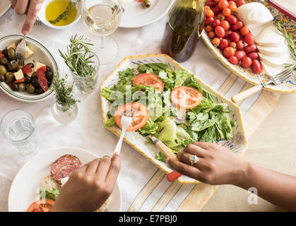 Mani che serve insalate Foto Stock