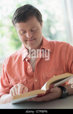 Uomo con la sindrome di down libro di lettura Foto Stock