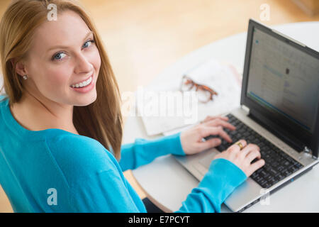 Sorridente giovane donna utilizzando laptop Foto Stock