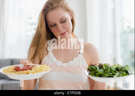 Donna scegliendo tra pasta e insalate Foto Stock