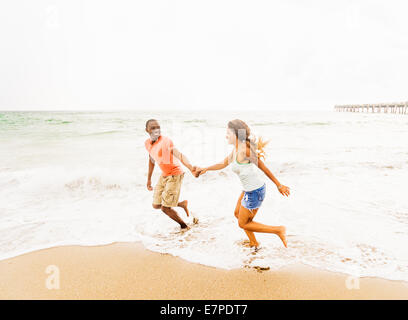 Stati Uniti d'America, Florida, Giove, coppia giovane in esecuzione sulla spiaggia Foto Stock