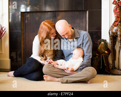 I genitori a guardare la loro baby (2-5 mesi) dormire Foto Stock