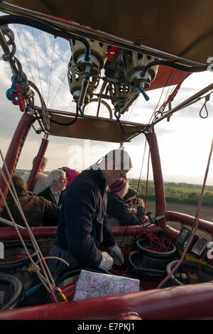 Sterzo pilota una mongolfiera con passeggeri godendo la vista, Shropshire, Regno Unito Foto Stock