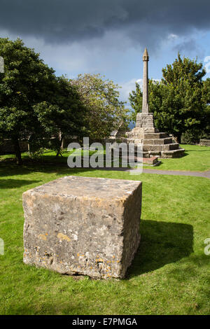 Un cubo di pietra di un metro e mezzo conosciuto come Dole Stone e croce nel cortile di San Michele L'Arcangelo a Dundry fuori Bristol Regno Unito Foto Stock