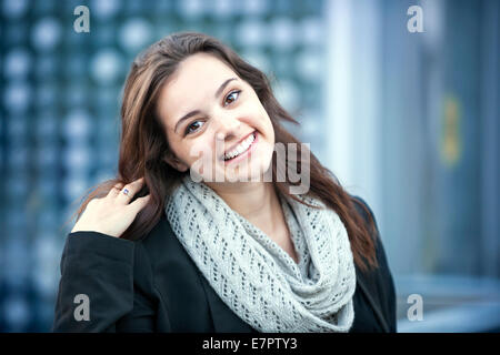 Ritratti di giovani brunette donna sorridente e toccando i capelli con lo spazio di copia Foto Stock