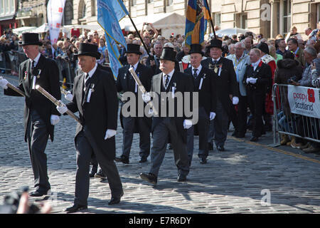 Una processione di padri della città e gli anziani marciando nella parte anteriore del folle sul Royal Mile di Edimburgo. Foto Stock