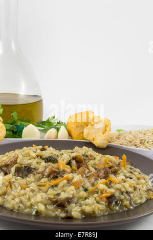 Una piastra di " " risotto con funghi e i suoi ingredienti su sfondo bianco Foto Stock