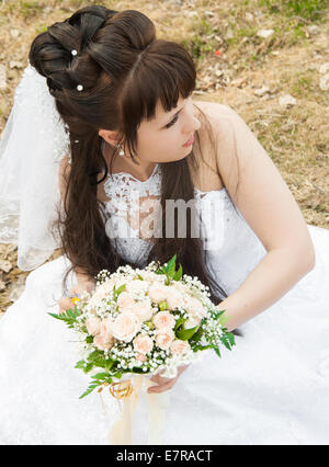 Sposa con un mazzo di fiori in un abito da sposa Foto Stock