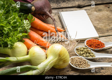 Ricetta dello sfondo. Verdure fresche e spezie con pagina vuota del Cookbook. Foto Stock