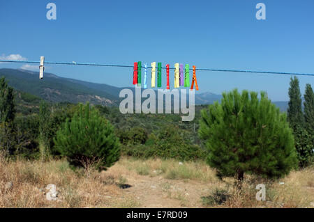 Clothespin multicolore impiccati sul cavo Foto Stock