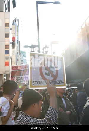 Tokyo, Giappone. 23 Settembre, 2014. Un anti-razzista detiene un poster durante una manifestazione contro i razzisti' marzo a Tokyo, Sett. 23, 2014. Centinaia di membri della Zaitokukai, un ultra-gruppo di destra contro i privilegi estesi a stranieri che hanno concesso speciali estera dello status di residente, raccolse e hanno marciato in Roppongi, una area del centro cittadino di Tokyo e si sono scontrate con anti-razzisti qui il lunedì, evidenziando il Giappone del nazionalismo-questione pendente. Credito: Liu Tian/Xinhua/Alamy Live News Foto Stock
