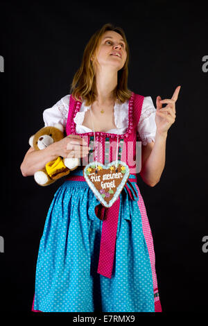 Donna in dirndl puntando verso qualcosa di Foto Stock