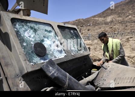 (140923) -- SANAA, Sett. 23, 2014 (Xinhua) -- Un uomo yemenita guarda un veicolo blindato distrutto in scontri fra sciiti Houthi ribelli e esercito in Sanaa, Yemen, sul Sett. 23, 2014. Il gruppo Houthi e il governo dello Yemen ha firmato un affare di cessate il fuoco di domenica, per porre fine alla settimana di scontri che hanno lasciato più di 400 persone uccise. Houthi fighters hanno rafforzato il loro controllo sulla maggior parte della capitale fino a martedì, distribuzione di combattenti per la protezione di strutture governative e impostazione dei punti di controllo in città. (Xinhua/Hani Ali) Foto Stock