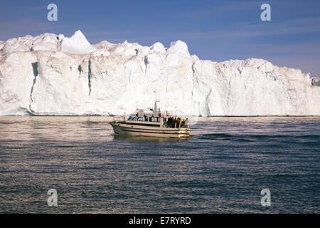 Tour barche offrono un occhiata al gigantesco iceberg che la strozzatura Disko Bay, nei pressi di Ilulissat. Foto Stock