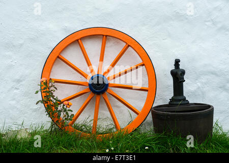 Appoggiate e lavare la benna al di fuori di un tradizionale del XIX secolo irlandese tetto di paglia cottage, Malin Head, County Donegal, Irlanda. Foto Stock