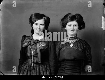 Questa fotografia raffigura due donne dell'inizio del XX secolo. Una donna è vestita con un tradizionale abbigliamento islandese, chiamato "peysuföt", mentre l'altra indossa un abito danese. La foto cattura i loro diversi costumi culturali dal 1900 al 1920 circa. Foto Stock