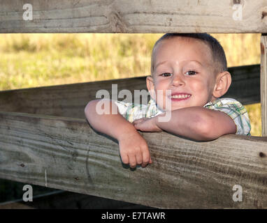 4-5 anno vecchio ragazzo nel fienile sorridente di stallo Foto Stock