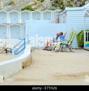 Lusty Glaze beach, un anziana coppia senior rilassante Newquay Cornwall Inghilterra Regno Unito Foto Stock