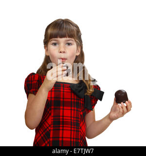 Carino bambina mangia torte. Ritratto isolato su sfondo bianco Foto Stock