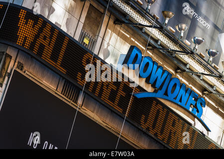 Una scritta al neon visualizza le ultime Wall Street Journal in primo piano sotto il Dow Jones logo in Times Square e Midtown Manhattan Foto Stock