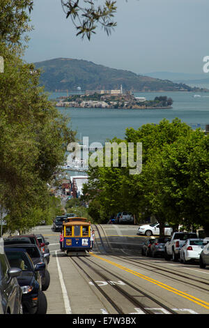 Macchina di cavo su Hyde Street, e l'Isola di Alcatraz a San Francisco Bay, San Francisco, California, Stati Uniti d'America Foto Stock