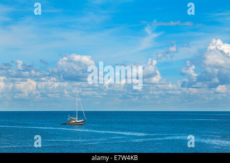 Isolato su barche a vela blu oceano mare con soffici nuvole nel cielo blu chiaro guardando riposante calma rilassante isolato p isolata Foto Stock