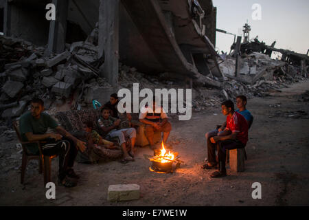 Striscia di Gaza, Shejaiya quartiere di Gaza City. 24Sep, 2014. Gli uomini palestinesi accende un fuoco per illuminare il loro quartiere, che è stato distrutto durante la 50-giorno del conflitto tra Israele e Hamas, nel quartiere Shejaiya di Gaza City, a settembre 24, 2014. © Wissam Nassar/Xinhua/Alamy Live News Foto Stock