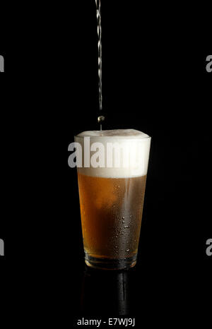 Traboccante di vetro di birra Foto Stock