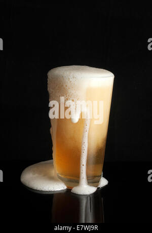 Traboccante di vetro di birra Foto Stock