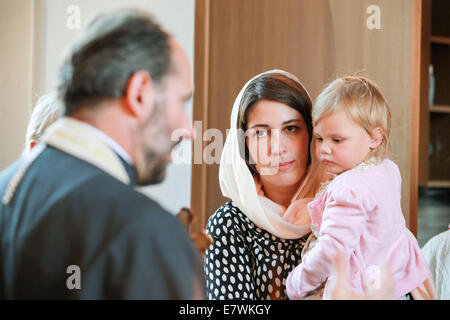 ST.PETERSBURG, Russia - 21 settembre 2014: sacerdote ortodosso esegue il rito del battesimo per un po' di Russo ragazza Foto Stock