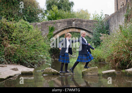 Ragazze imbarco a re la Scuola di attraversare il fiume Brue nel Somerset villaggio di Bruton REGNO UNITO Foto Stock