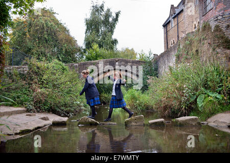 Ragazze imbarco a re la Scuola di attraversare il fiume Brue nel Somerset villaggio di Bruton REGNO UNITO Foto Stock